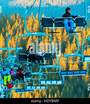 Skiers and snowboarders on a ski lift in Bukovel. Bukovel is the most popular ski resort in Ukraine. Stock Photo