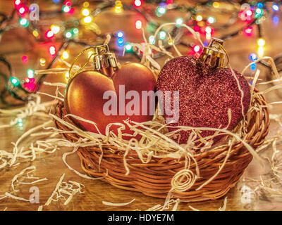 Christmas shiny balls in beautiful wooden wicker basket next to a bright garland Stock Photo