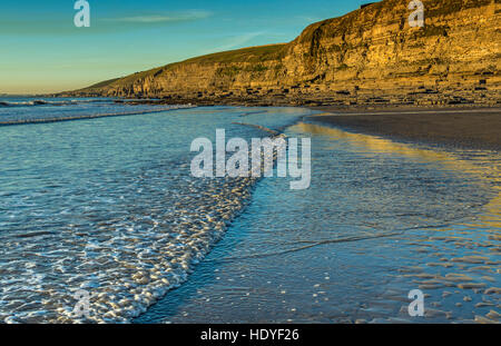 The shoreline on Dunraven Bay, Southerndown, on a bright and cold winter evening just before sunset Stock Photo