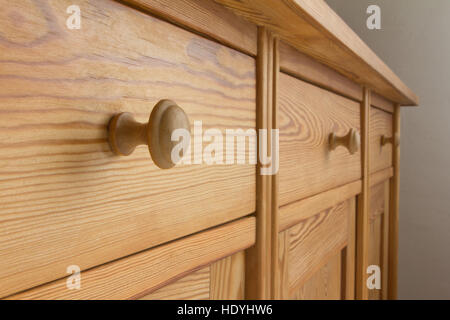 Three drawers of a vintage chest with knobs or handles, natural brown soft wood, old wooden furniture, close up Stock Photo