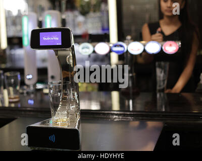 A demonstration takes place of the world's first contactless, self-serving beer pump developed by Barclaycard to help cut bar queues on nights out, at Henry's Cafe and Bar in Piccadilly, London. Stock Photo