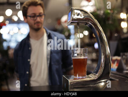 James Miller, who helped to develop the world's first contactless, self-serving beer pump with Barclaycard to help cut bar queues on nights out, takes part in a demonstration at Henry's Cafe and Bar in Piccadilly, London. Stock Photo