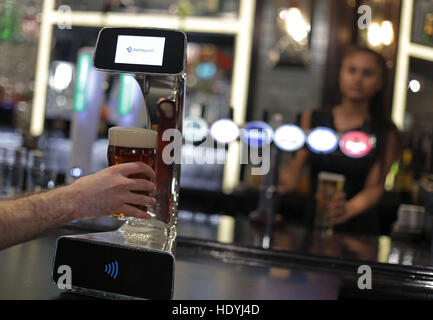 Embargoed to 0001 Friday December 16 A demonstration takes place of the world's first contactless, self-serving beer pump developed by Barclaycard to help cut bar queues on nights out, at Henry's Cafe and Bar in Piccadilly, London. Stock Photo