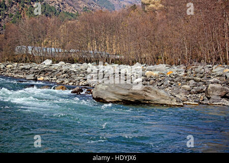 Beas river forming rapids while flowing through granite boulders at the Manali region of the Himalayas. White water rafting is a popular sport here. Stock Photo