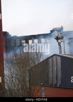 Oldham Lancashire, UK. 15th Dec, 2016. Huge fire was attended by the Greater Manchester Fire Services in Oldham Lancashire, at one stage the flames were roaring above the building. The whole surrounding area was cordoned off as the fire fighters battled with the blaze. Credit:  jozef mikietyn/Alamy Live News Stock Photo