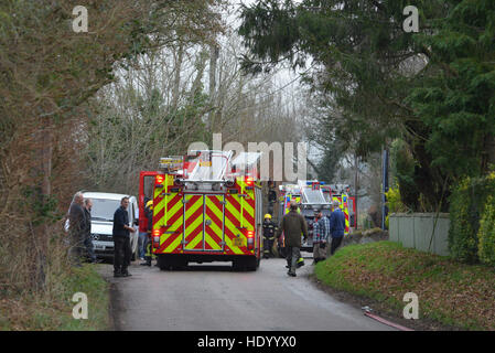 Fire brigade attending a fire at a rural property on a country lane.