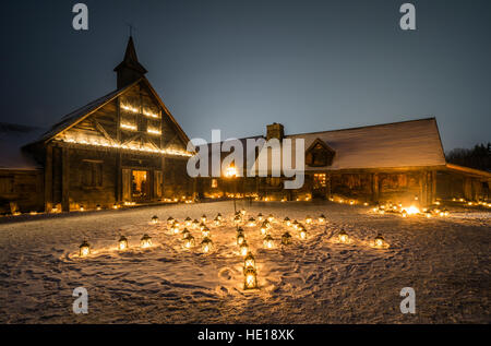 Rustic Cabins at Twilight Illuminated by the Glow of Candle Lanterns at Christmas time Stock Photo