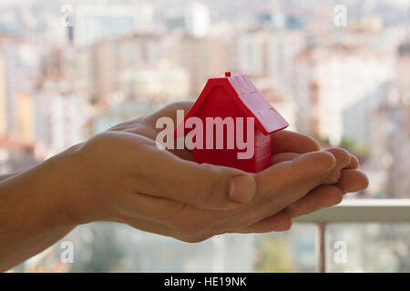 Small red house in the man's hands Stock Photo