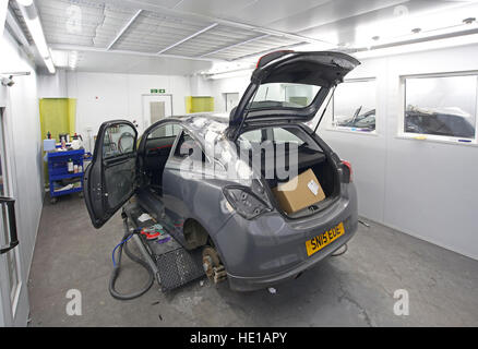 A car undergoing bodywork repairs in a clean, modern service centre prior to repainting Stock Photo