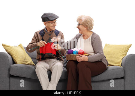 Mature woman showing a mature man how to knit isolated on white background Stock Photo