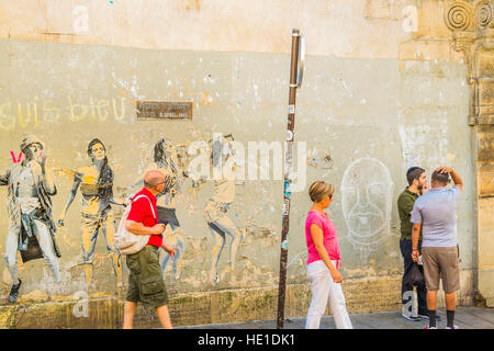 street scene in front of graffito showing dancing young people Stock Photo