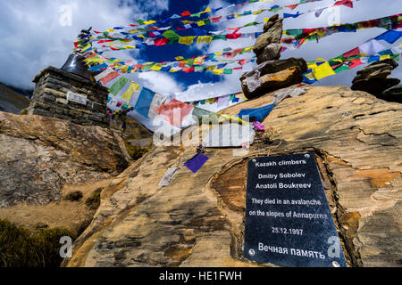 Many tibetan prayer flags are set up at a memotial for died climbers, a black signpost is naming Anatoli Boukreev Stock Photo