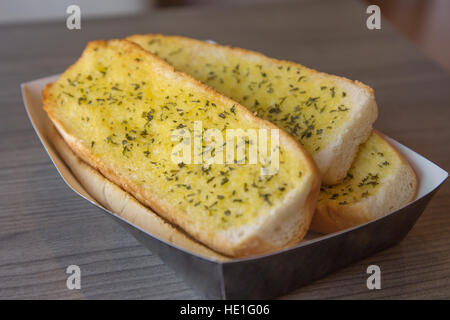 Close up of crunchy garlic baguette on the wooden table. Stock Photo