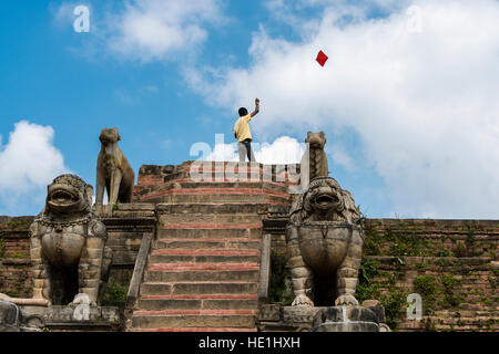 A boy is flying a kite on the ruins of the during the 2015 earthquake destroyed temple Shilu Mahadev Mandir Stock Photo