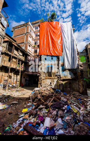 A building in the city got damaged during 2015 earthquake and is covered by plastic sheets Stock Photo