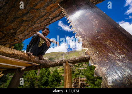 Detail of a blade saw, a worker is sitting on a wooden scaffold Stock Photo
