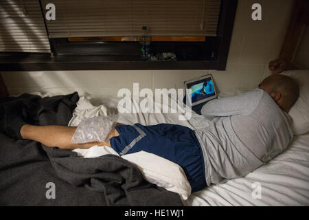 Staff Sgt. Spencer Wallace, 435th Security Forces Squadron, senior instructor, Ramstein Air Base, Germany, recovers with ice packages on his knees after a day of training during the Phoenix Raven Qualification Course at Joint Base McGuire-Dix-Lakehurst, N.J. The intensive three-week, 12-hour-a-day course covers such subjects as cross-cultural awareness, legal considerations, embassy operations, airfield survey techniques, explosive ordnance awareness, aircraft searches, and unarmed self-defense techniques. Students are exposed to more than 70 use-of-force scenarios where stress is simulated us Stock Photo