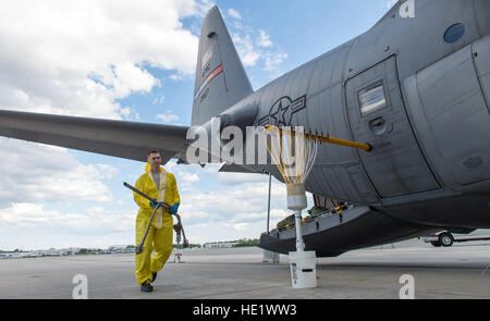 Tech. Sgt. Thomas Neiswanger, 910th Maintenance Squadron, carries a hose to transfer insecticide from barrels to the tanks of a C-130 Hercules at Joint Base Charleston, S.C. May 5, 2016. Spraying less than one ounce of the chemical per acre effectively limits the mosquito population near the base. The mission of the 910th at Youngstown Air Reserve Station, Ohio, is to maintain the Department of Defense's only large area fixed-wing aerial spray capability to control disease-carrying insects, pest insects, undesirable vegetation and to disperse oil spills in large bodies of water. /Master Sgt. B Stock Photo