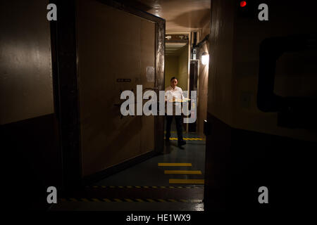 Airman 1st Class Alexandra Ayub walks through a blast door to deliver a meal to the missileers manning the launch control center which is approximately 60 feet beneath the missile alert facility. /Staff Sgt. Andrew Lee Stock Photo