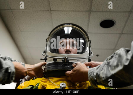 U.S. Air Force 9th Physiology Support Squadron launch and recovery technicians secure the helmet of a full pressure suit for a U-2S pilot in preparation for a flight at Beale Air Force Base, California, June 15, 2016. The suit allows U-2S pilots to safely fly at altitudes reaching 70,000 feet.  Staff Sgt. Kenny Holston Stock Photo