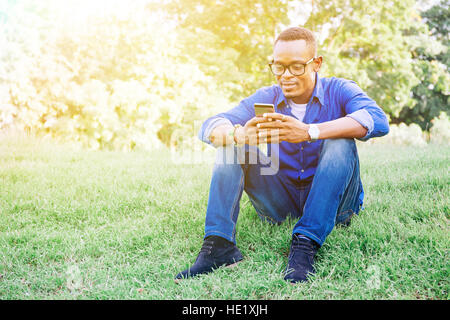 African American man using mobile phone in the park Stock Photo