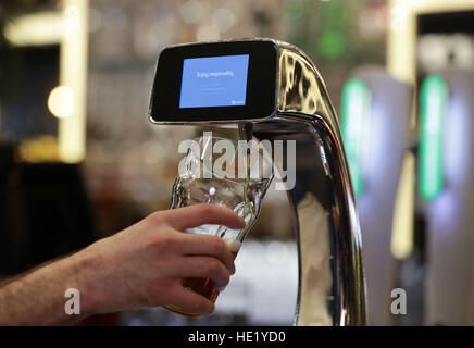 A demonstration takes place of the world's first contactless, self-serving beer pump developed by Barclaycard to help cut bar queues on nights out, at Henry's Cafe and Bar in Piccadilly, London. Stock Photo