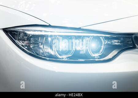 Closeup headlights of modern car during turn on light in night. Stock Photo