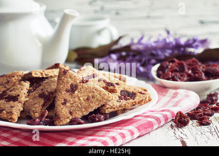 Whole wheat cookies with dried cranberries on white rustic wooden background