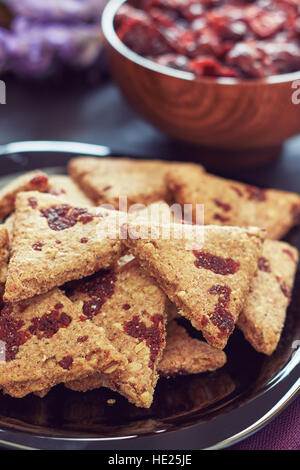 Whole wheat cookies with dried cranberries on black wooden background
