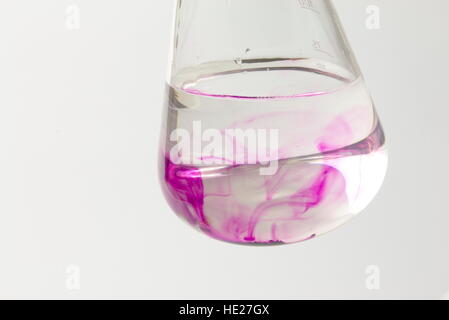 Crystals of potassium permanganate dissolving in water Stock Photo