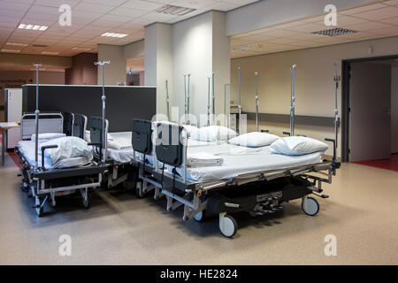 Group of unused empty hospital beds on corridor waiting to be used for patients Stock Photo