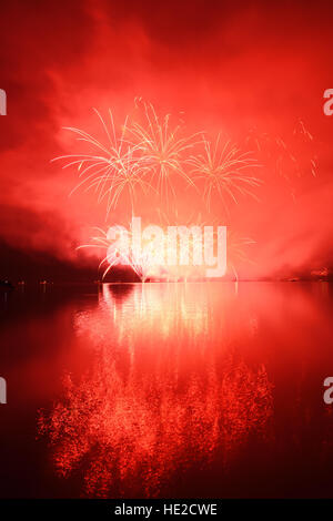 Colorful spectacular fireworks reflecting in water Stock Photo