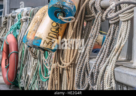 A close view of ropes, floats and a life ring hanging from the rail of a commercial fishing boat on Canada's west coast. Stock Photo