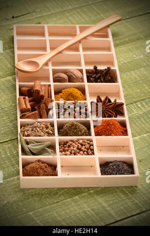 assorted spices in a wooden box on the table Stock Photo