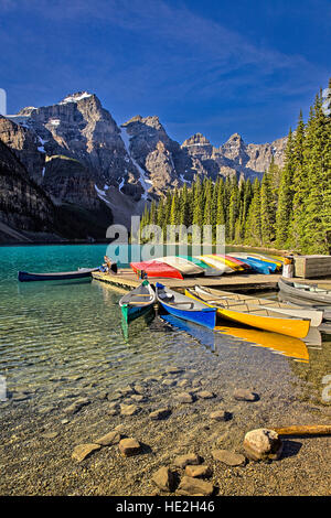 Two tourists relax on the dock at Moraine Lake in Banff National Park Alberta Canada Stock Photo