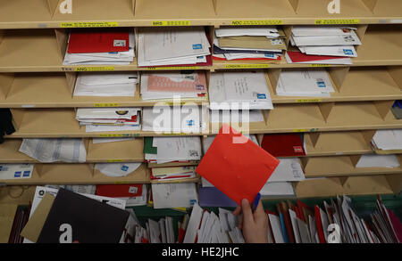 A Royal Mail worker sorts mail at the Royal Mail's Sorting Office in Turner Road, Glasgow, where postal workers are handling some of the millions of items of Christmas mail on what is expected to be one of their busiest day of the year. Stock Photo