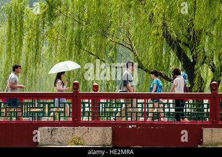 Visitors crossing East Causeway Bridge in the Summer Palace and Kunming Lake Beijing, China. Stock Photo