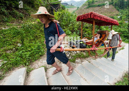 Sedan chair carriers litter Longsheng Longji Dragon Spine Rice Terraces fields on hillside Longsheng, guilin, Guangxi, China. Stock Photo