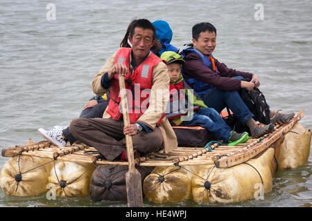 Chinese tourists floating on Yellow River sheepskin raft at Shapotou Tourism Area, Zhongwei, Ningxia, China Stock Photo