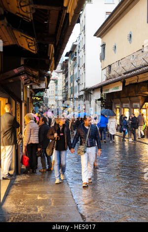 FLORENCE, ITALY - NOVEMBER 5, 2016: people in shopping area on Ponte Vecchio (Old Bridge) in Florence in autumn. The Ponte Vecchio is medieval stone b Stock Photo