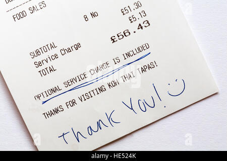 Optional service charge is included on restaurant bill with hand written thank you and smiley face Stock Photo