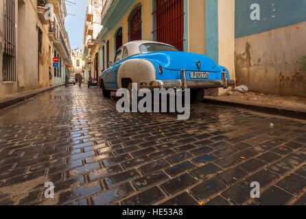 A classic car and a wet cobblestone road in Old Havana, Cuba. Stock Photo