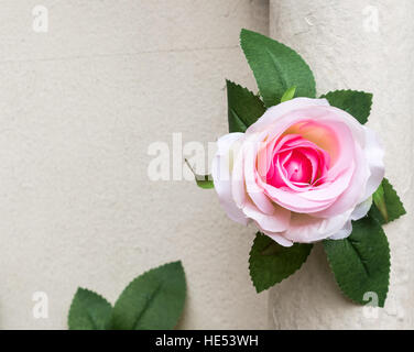 Artificial pink rose is decorated on the cement pillar. Stock Photo
