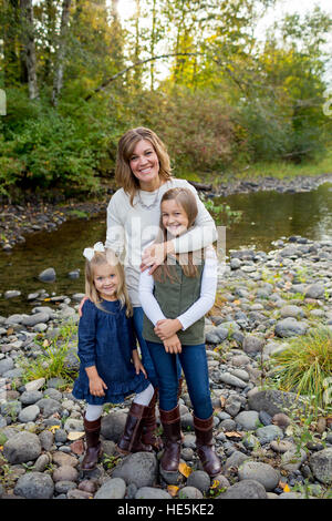 Portrait of a mother with her two daughters along the McKenzie River in Oregon. Stock Photo