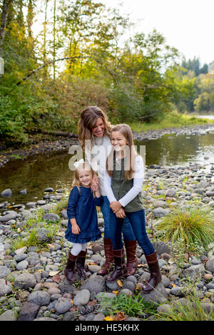 Portrait of a mother with her two daughters along the McKenzie River in Oregon. Stock Photo