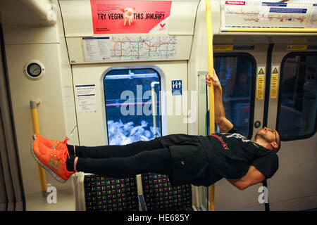 London Underground, London, UK. 19th December, 2016. London commuters are treated to a flash performance by pole acrobats from Ireland, Terri Walsh and Michael Donohoe, as Veganuary launch the first ever vegan advertising campaign on the London Underground. The adverts are created by Veganuary – the charity that encourages people to try vegan in January. Credit: Dinendra Haria/Alamy Live News Stock Photo