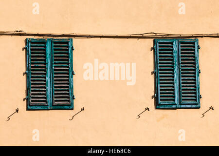 travel to Italy - closed green windows on yellow wall of old house in Florence city Stock Photo