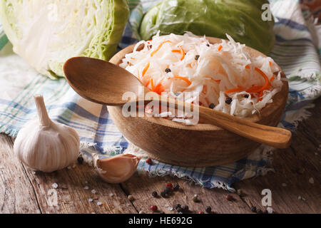 sauerkraut and carrots in a wooden plate closeup and ingredients. horizontal, rustic Stock Photo