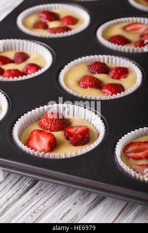raw strawberry muffins in baking dish macro. vertical Stock Photo