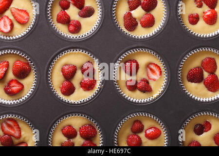 raw strawberry muffins in baking dish closeup. Horizontal top view Stock Photo